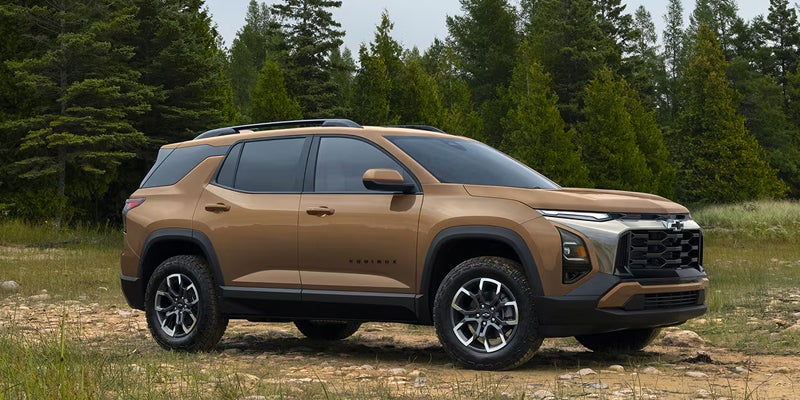 2027 Chevrolet Equinox ACTIV side profile parked on a forest trail